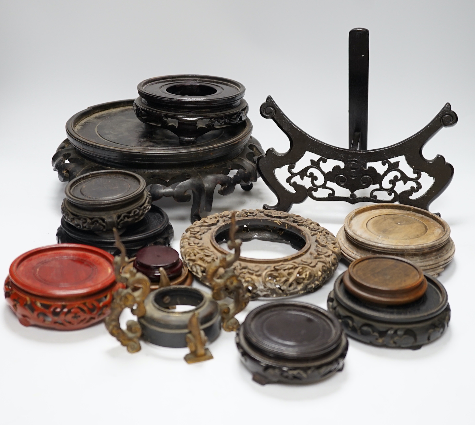 Assorted Chinese wooden and metal stands, largest 25cm in diameter